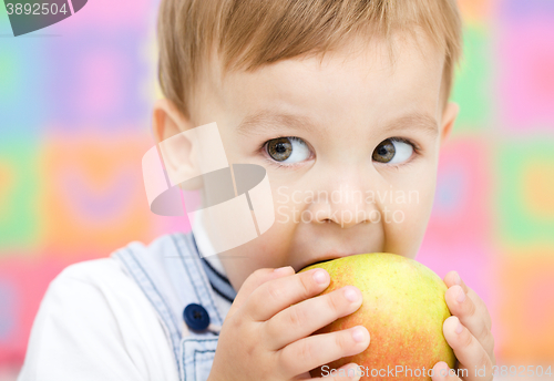 Image of Little child is biting red apple