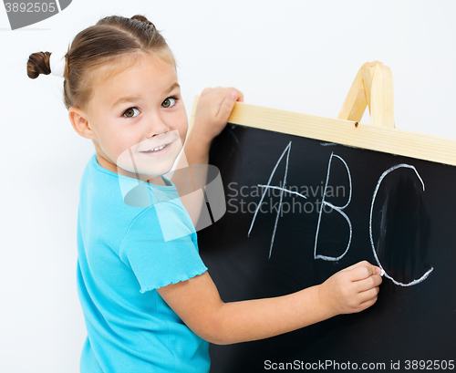 Image of Little girl is showing letter E on the alphabet