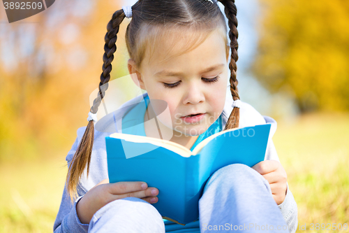 Image of Cute little girl reads a book