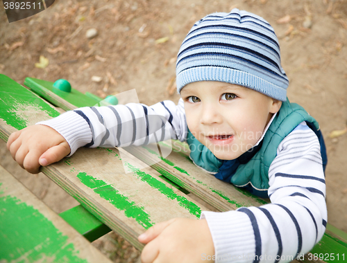 Image of Little boy is playing on playground