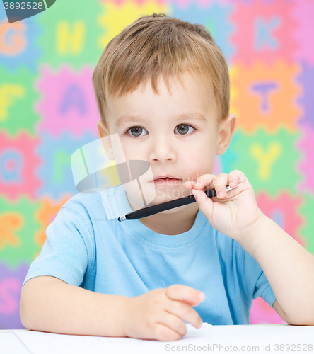 Image of Little boy is writing on his copybook