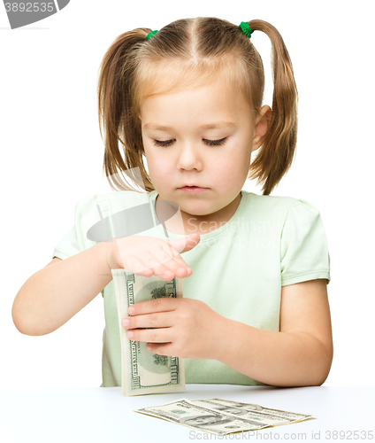 Image of Little girl is counting dollars