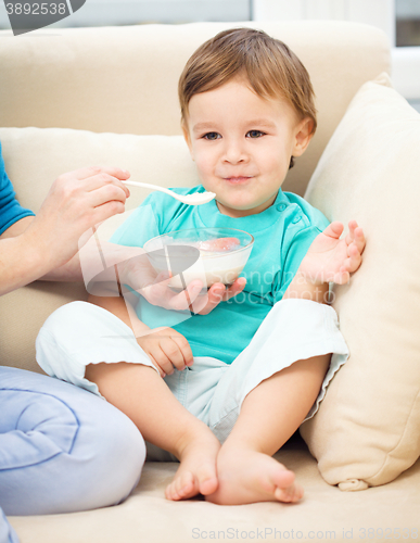 Image of Cute little boy is fed using spoon