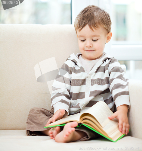 Image of Little boy is reading book