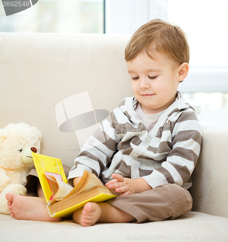 Image of Little boy is reading book