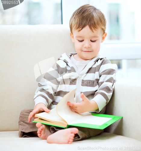 Image of Little boy is reading book