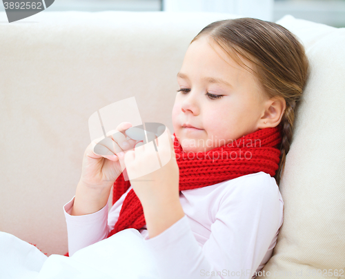 Image of Ill little girl is reading thermometer