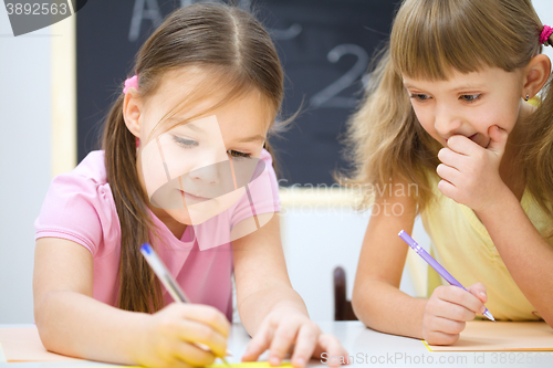 Image of Little girls are writing using a pen