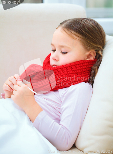 Image of Ill little girl is reading thermometer