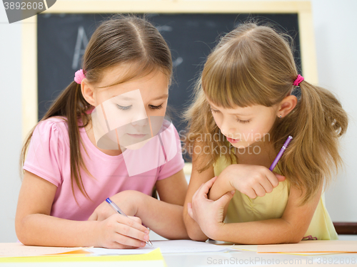 Image of Little girls are writing using a pen