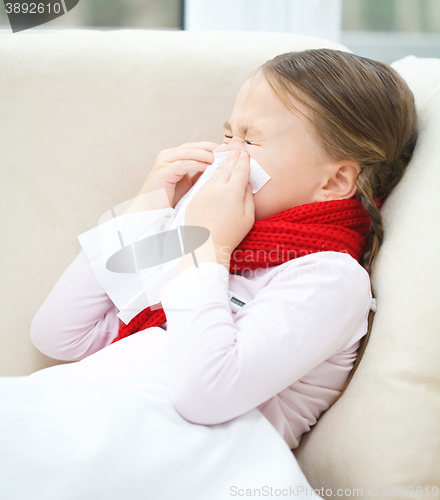 Image of Little girl is blowing her nose