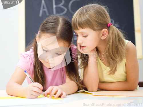 Image of Little girls are writing using a pen