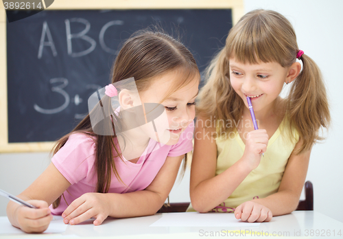 Image of Little girls are writing using a pen