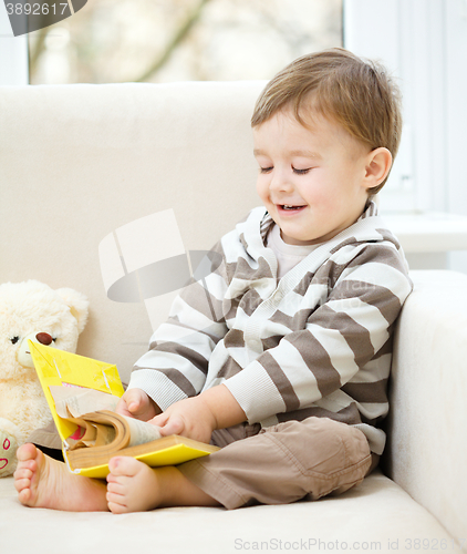 Image of Little boy is reading book