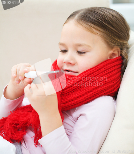 Image of Ill little girl is reading thermometer