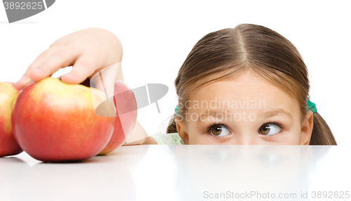 Image of Little girl is reaching apple