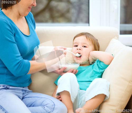 Image of Cute little boy is fed using spoon