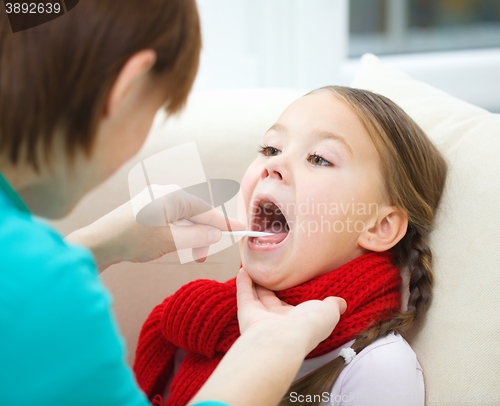 Image of Doctor is examining little girl