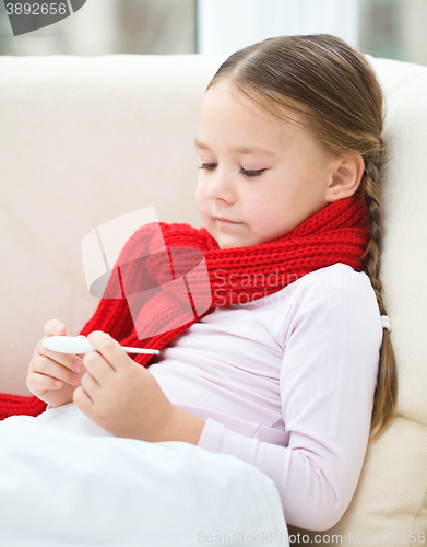 Image of Ill little girl is reading thermometer