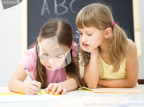 Image of Little girls are writing using a pen