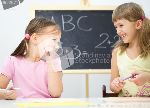 Image of Little girls are writing using a pen