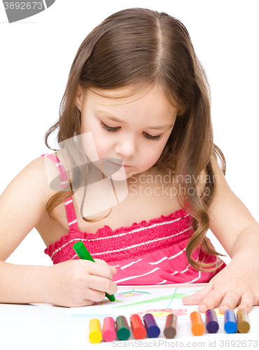 Image of Little girl is drawing using a crayon