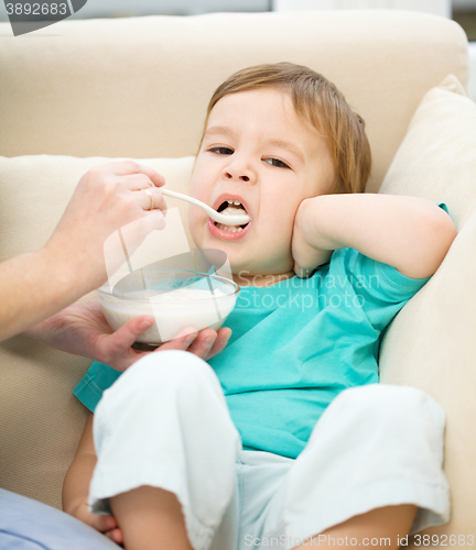 Image of Cute little boy is fed using spoon