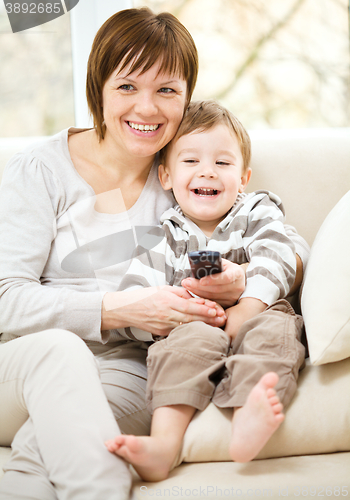 Image of Mother and her son are watching tv show