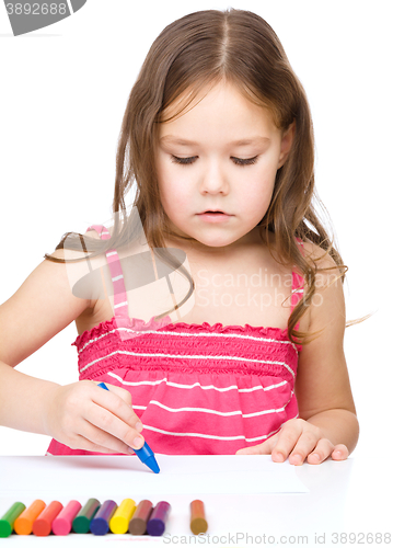 Image of Little girl is drawing using a crayons