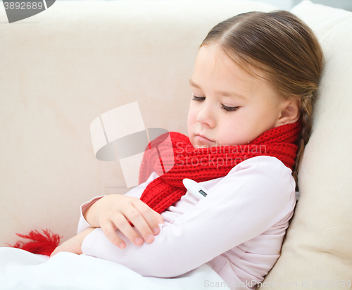 Image of Ill little girl with thermometer in her mouth