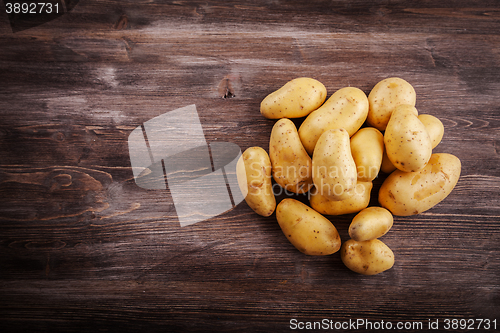 Image of Fresh organic potatoes on a wooden table