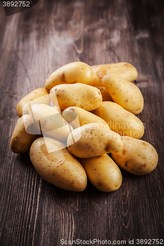 Image of Fresh organic potatoes on a wooden table