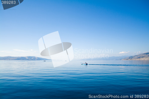 Image of blue sky above a blue surface of the sea