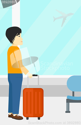 Image of Man at airport with suitcase.