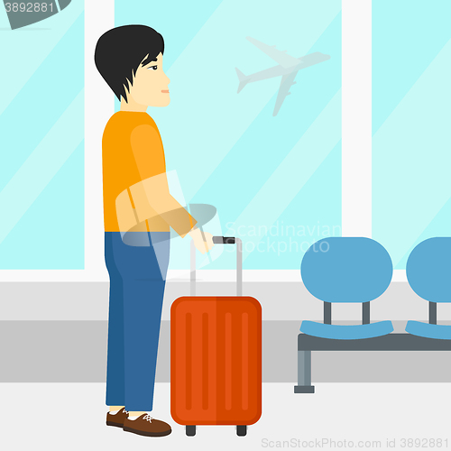 Image of Man at airport with suitcase.