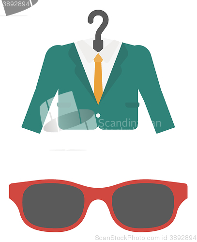 Image of Suit on hanger and sunglasses.