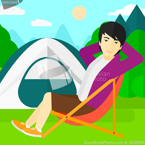 Image of Man sitting in folding chair.