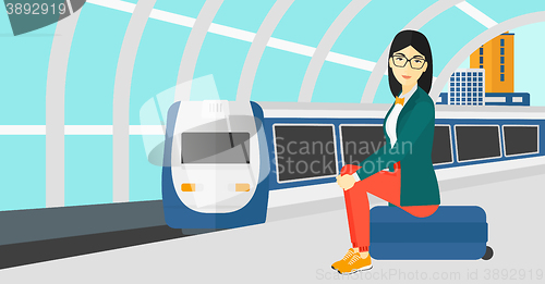 Image of Woman sitting on railway platform.