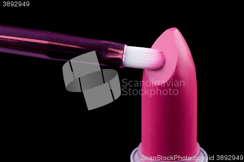 Image of Tube of lipstick with a brush make-up on black 