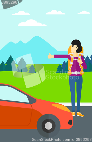 Image of Young woman hitchhiking.