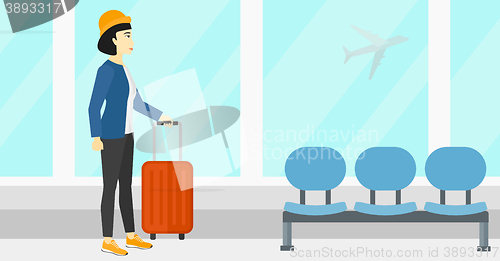 Image of Woman at airport with suitcase.