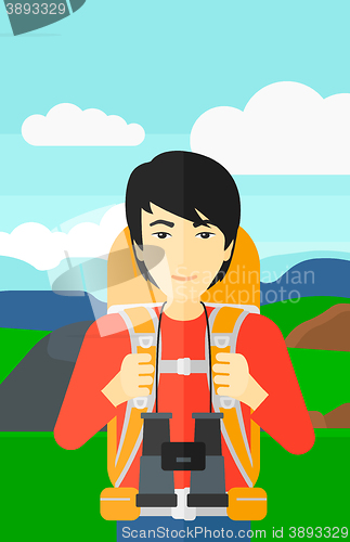 Image of Cheerful backpacker with binoculars.