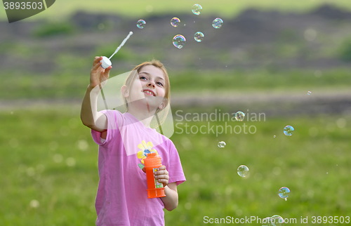 Image of little girl play with soap bubbles