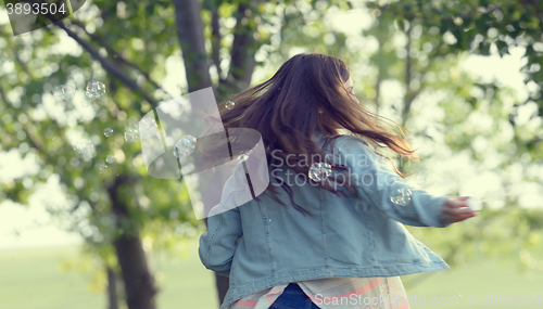 Image of Young girl play with soap-bubbles