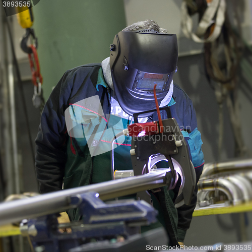 Image of Industrial worker setting orbital welding machine.