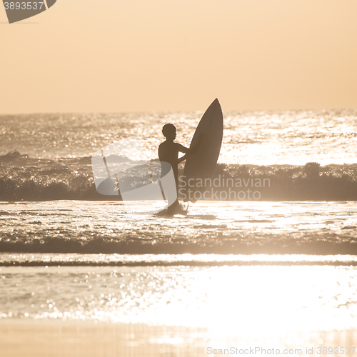 Image of Surfers on beach with surfboard.