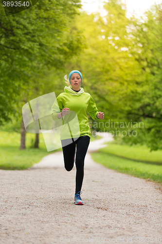 Image of Sporty young female runner in city park.. 