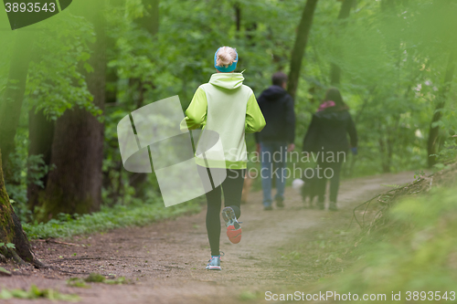 Image of Sporty young female runner in the forest. 