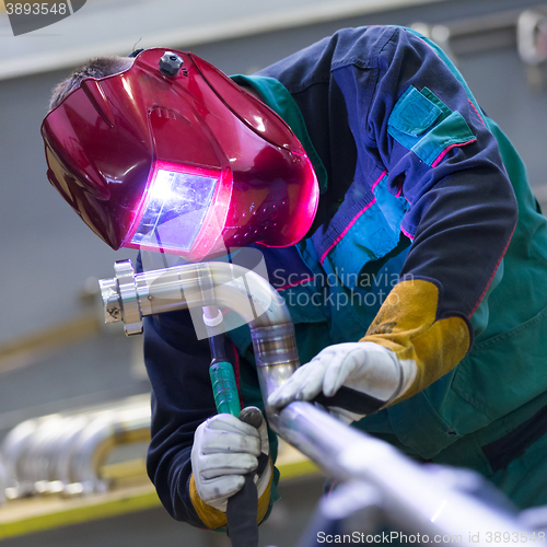 Image of Industrial worker welding in metal factory.