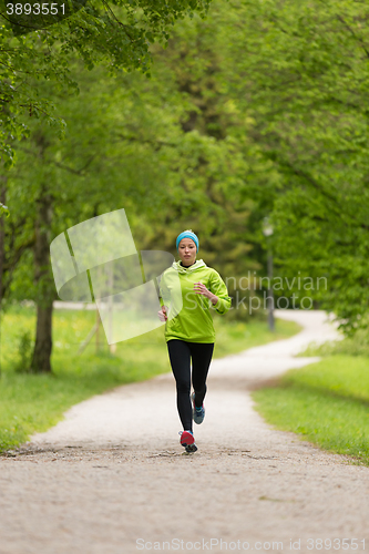 Image of Sporty young female runner in city park.. 